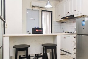 Fridge, stovetop, cookware/dishes/utensils, dining tables - White and Nice 1BR at Bassura City Apartment (Jakarta)