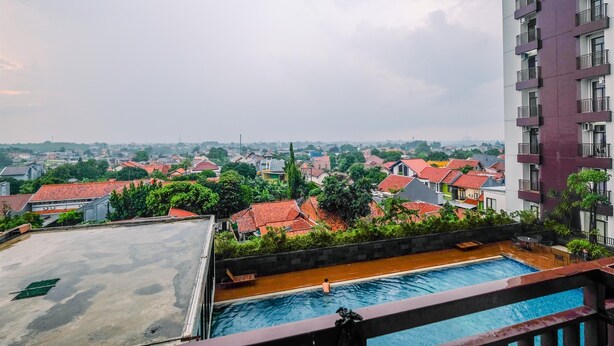 Ein Pool auf dem Dach mit Blick auf eine Wohngegend und ein hohes Gebäude.