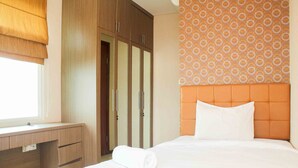 Hotellihuone, jossa on sänky, työpöytä ja vaatekaappi.
