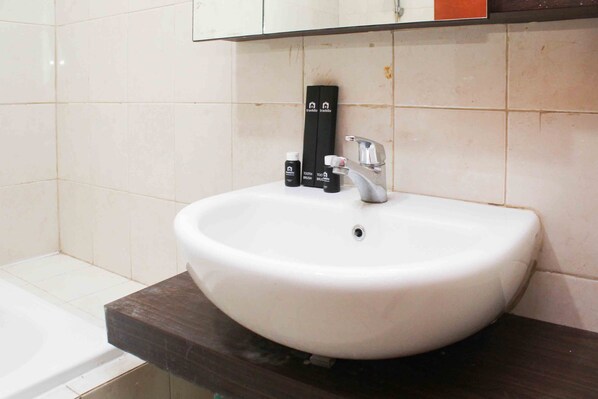 A bathroom with a white sink, a mirror above it, and a dark countertop.