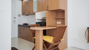 Une cuisine avec des meubles de rangement en bois, une table à manger et des chaises.