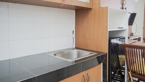 Une cuisine avec un plan de travail noir, des carreaux blancs et des armoires en bois.