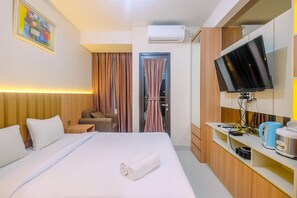 Une chambre d’hôtel équipée d’un lit, d’une télévision, d’un bureau avec une machine à café et d’une porte avec des rideaux.