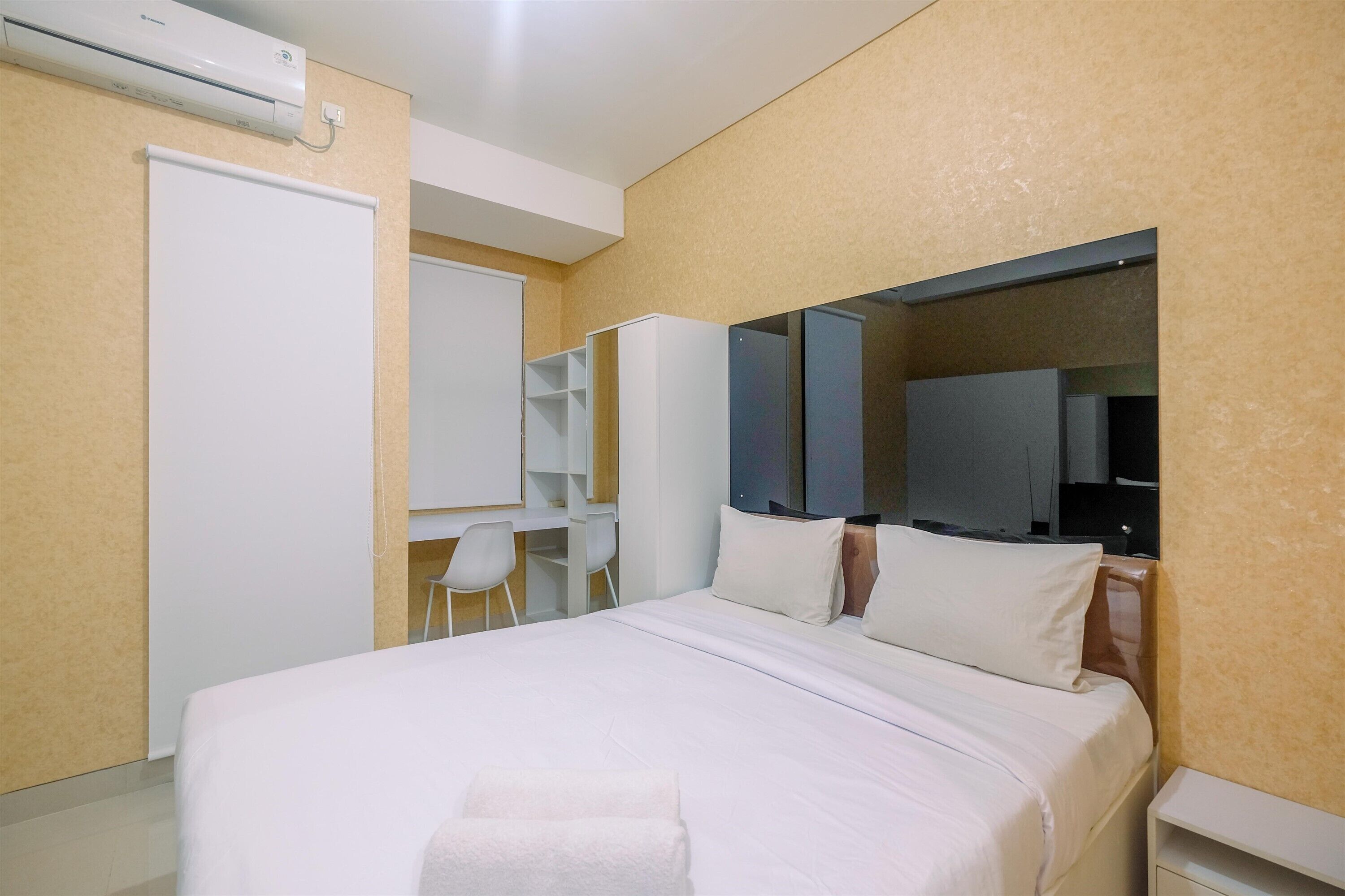 Een hotelkamer met een bed, een bureau, een stoel en een kledingkast.