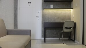 Une petite pièce comprenant un lit, un bureau et une chaise.