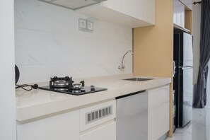 Fridge, stovetop, electric kettle, cookware/dishes/utensils - Fancy and Nice Studio at Sky House BSD Apartment (Pagedangan)
