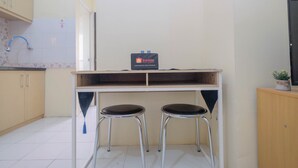 A small kitchenette with a sink, a travel bag, and two stools. - Nice and Comfy 1BR Apartment at MT Haryono Residence (Jakarta)