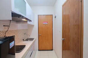 Fridge, stovetop, electric kettle, cookware/dishes/utensils - Comfy and Tidy Studio at Dave Apartment (Depok)