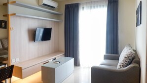 Een moderne woonkamer met een flatscreen televisie, een bank, een salontafel en een tv-meubel.