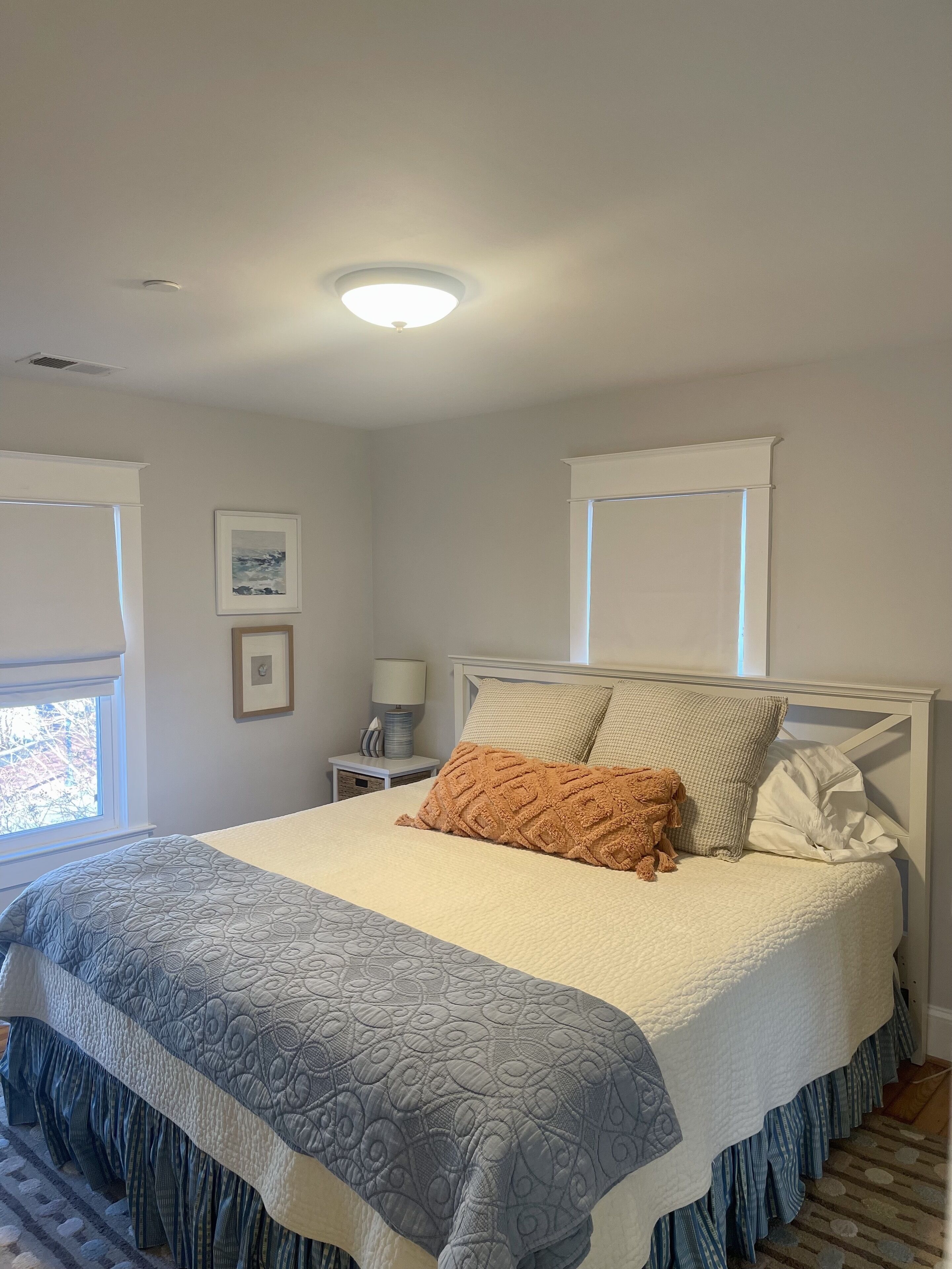 Un lit bien fait, avec une couvre-lit à motifs, des oreillers et un plaid décoratif.