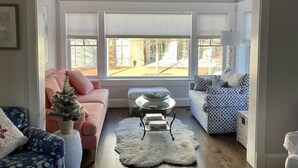 A living room with a pink sofa, a patterned sofa, a small white table, and a white furry rug. - Recently Renovated Annapolis Home - Conveniently Located (Annapolis)
