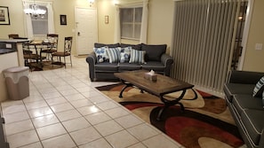 Un salon comprenant un canapé, une table basse et un coin repas avec des chaises et une table.