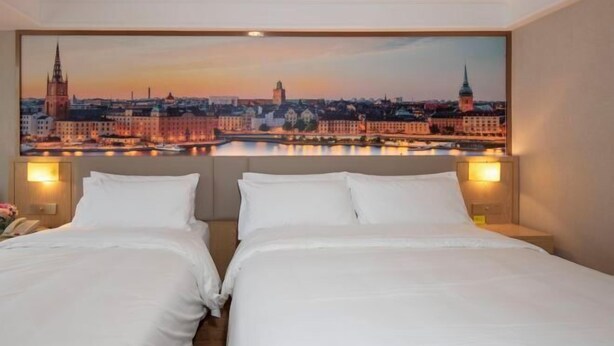 A hotel room with two beds, a cityscape view, and a night sky. - Vienna Classic Hotel (Hengdian Film and Television City Dream Valley) (Dongyang)