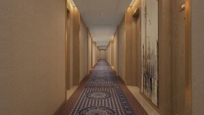 A long, narrow hallway with patterned carpet, wooden walls, and a ceiling with recessed lighting. - Vienna Classic Hotel (Hengdian Film and Television City Dream Valley) (Dongyang)