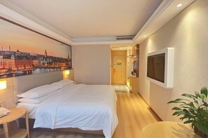 Ein Hotelzimmer mit Bett, Fernseher, einem Stadtbild als Gemälde und einer Pflanze.