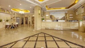 A hotel lobby with a reception desk, a dining area, and a reception counter. - Vienna Classic Hotel (Hengdian Film and Television City Dream Valley) (Dongyang)