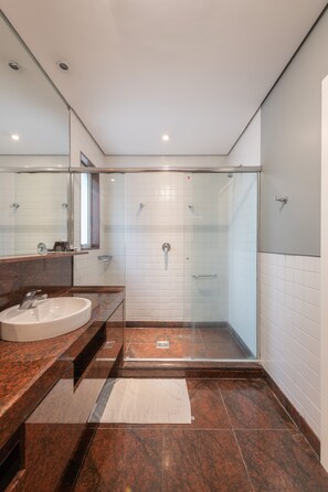 Deluxe driepersoonskamer | Badkamer | Een douche, een regendouche, een haardroger, handdoeken