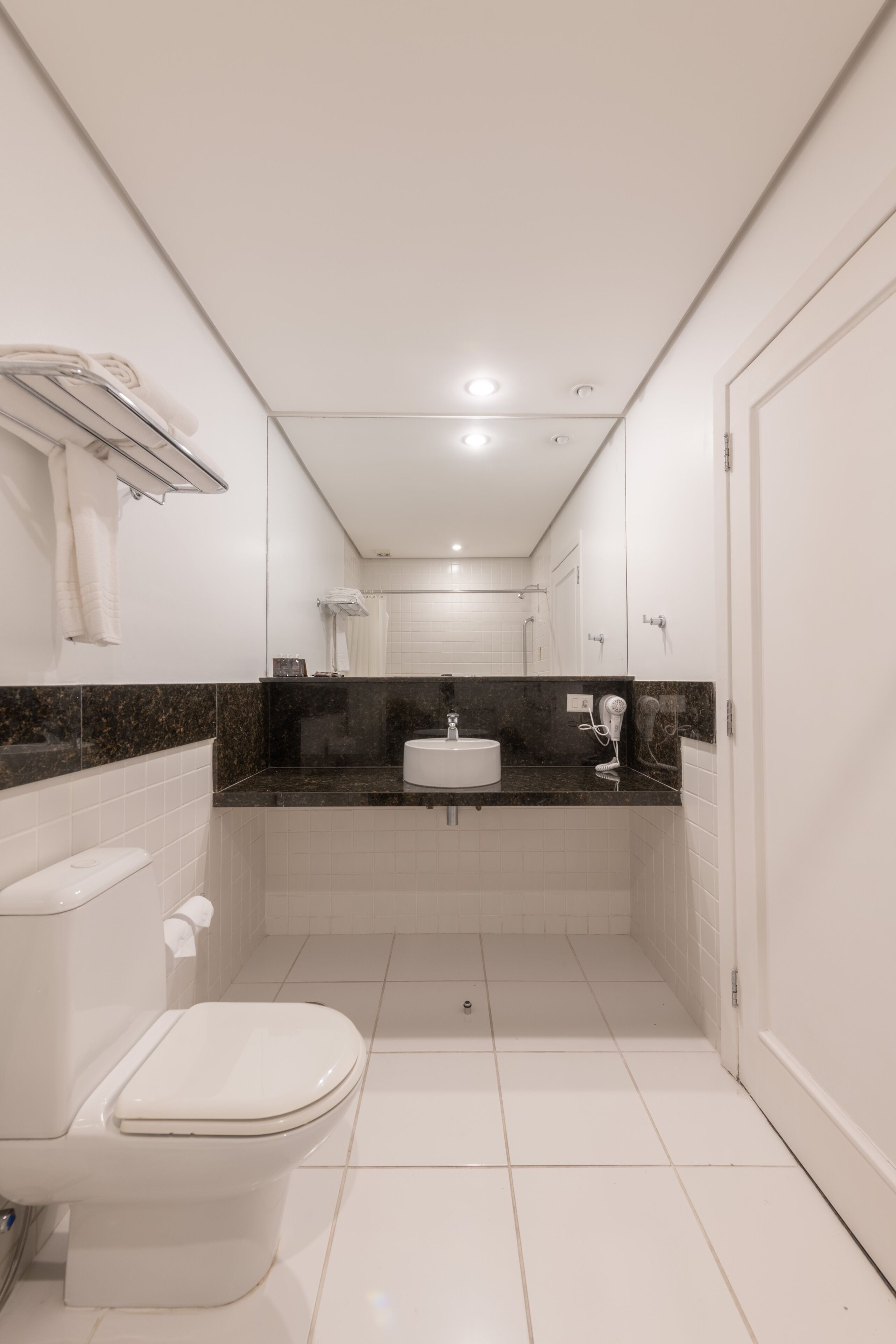 Un baño pequeño con inodoro, lavamanos y espejo.