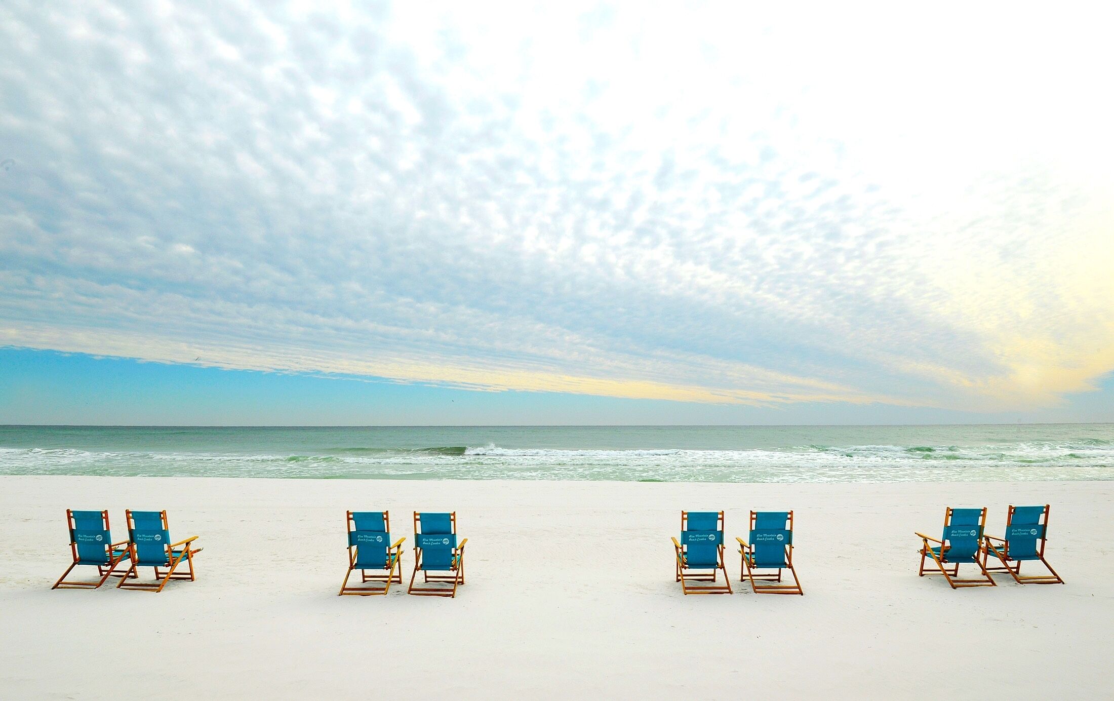 Rannalla, aurinkotuoleja, rantapyyhkeitä