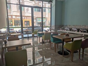 Un restaurante con una decoración moderna, amplios ventanales y vistas a la calle.