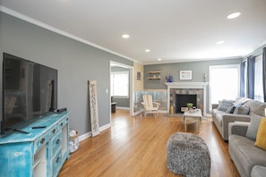 A living room with a television, a fireplace, a sofa, and a coffee table.