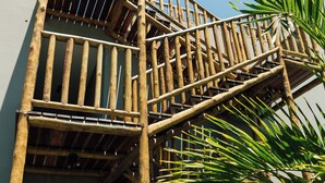 A bamboo staircase leading to a building entrance. - Vila Tuga (Cruz)