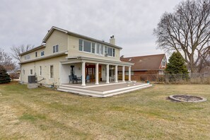 A two-story house with a covered porch and a fire pit in the yard. - Spacious Lakefront House w/ Backyard Fire Pit (Monroe)