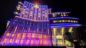 Een modern gebouw met een opvallende, gebogen gevel en verticale lichtaccenten.