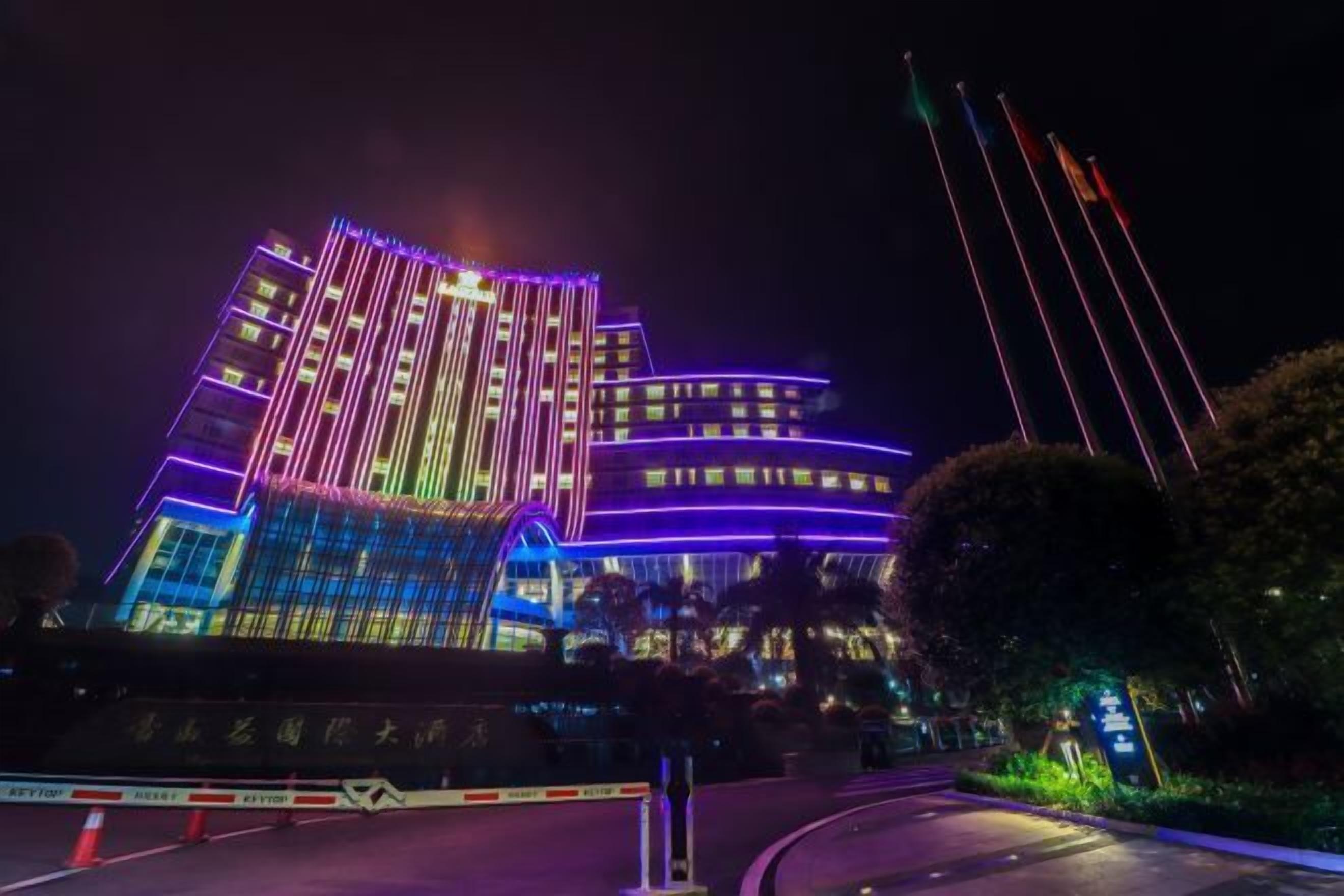 Un hotel de diseño moderno, con fachada curva y líneas verticales iluminadas.