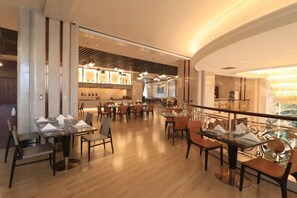 Un restaurant spacieux avec de hauts plafonds, un éclairage moderne et différents types d’aménagements pour s’asseoir.