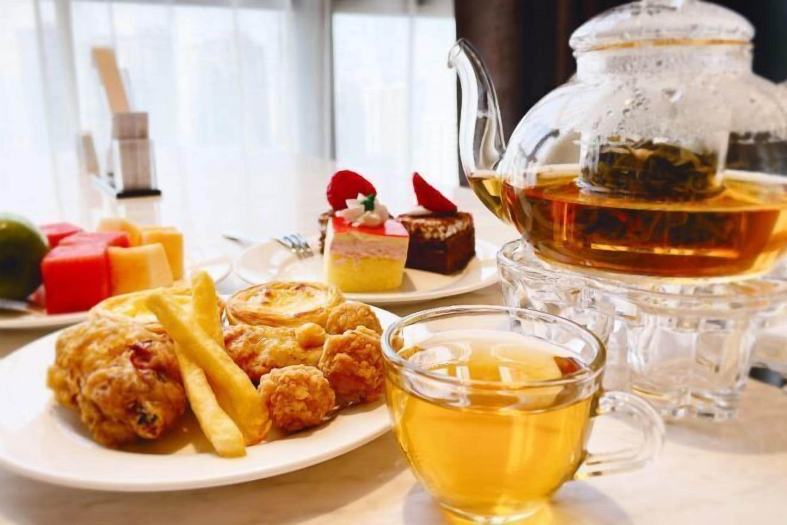 A table with a plate of food, a glass pitcher, and a cup of tea.