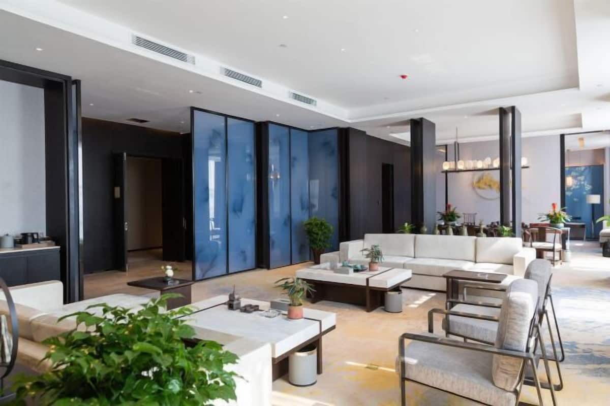 Un hall d’hôtel moderne avec un canapé, une table basse et des plantes en pot.