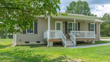 A single-story house with a front porch, a small staircase, and a number '181' on the wall.