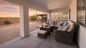 An outdoor patio with a sofa set, a table, and a pergola.
