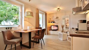 Una cocina moderna con comedor, televisor y vistas a zonas verdes.