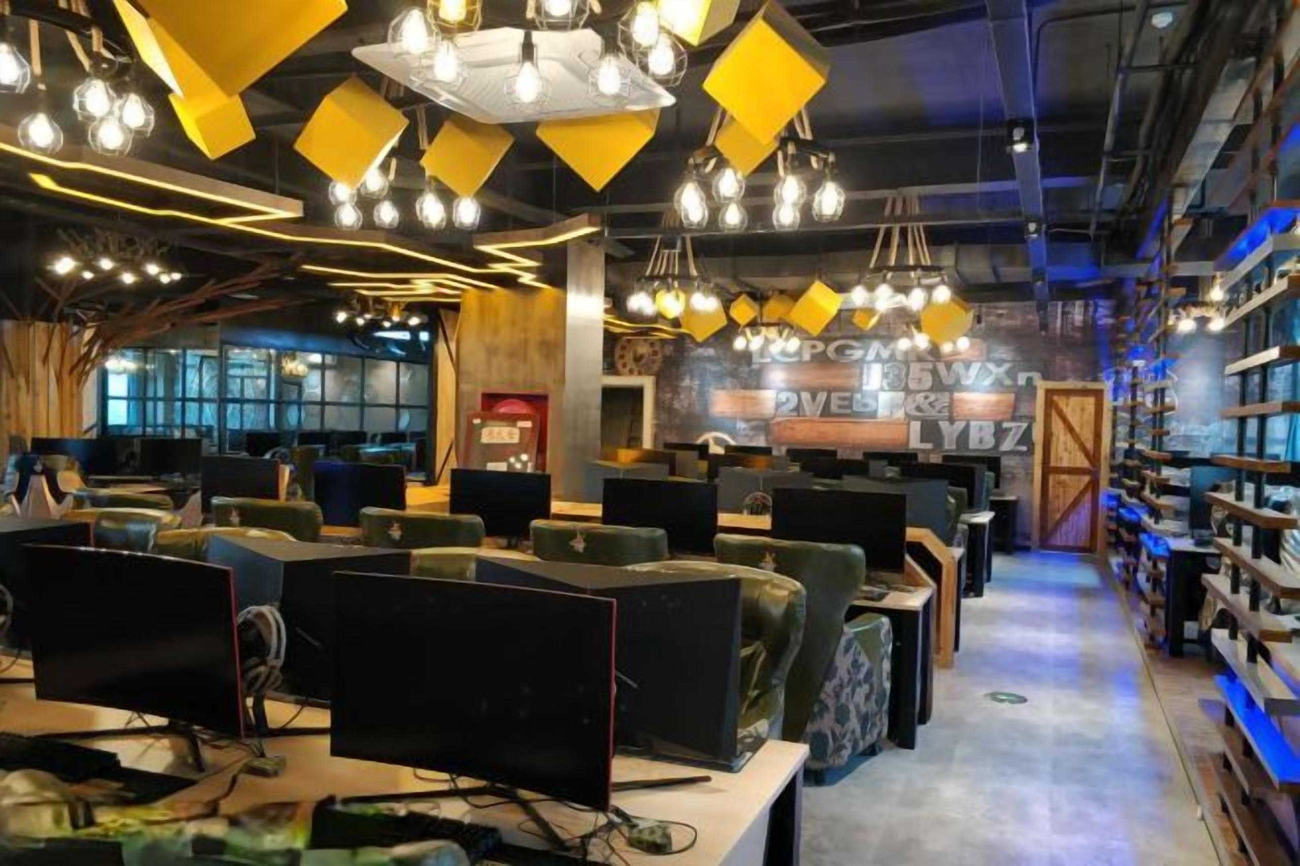 Un espacio de trabajo moderno con varias estaciones de computadoras, una barra central y estanterías llenas de libros y material de oficina.