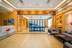 A hotel lobby with a reception desk, seating area, and a view of the outdoors. - Hefei Gui Jing Wan Hotel (Hefei)