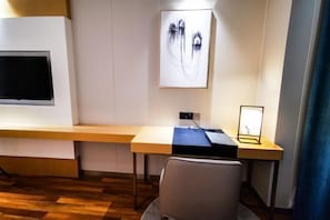 A modern office space with a desk, chair, and a large abstract painting on the wall. - Hefei Gui Jing Wan Hotel (Hefei)