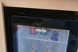 A glass display case with various items, including a red and a green container, and a blue object. - Hefei Gui Jing Wan Hotel (Hefei)