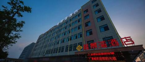 A multi-story hotel with a prominent red sign indicating a restaurant on the ground floor.