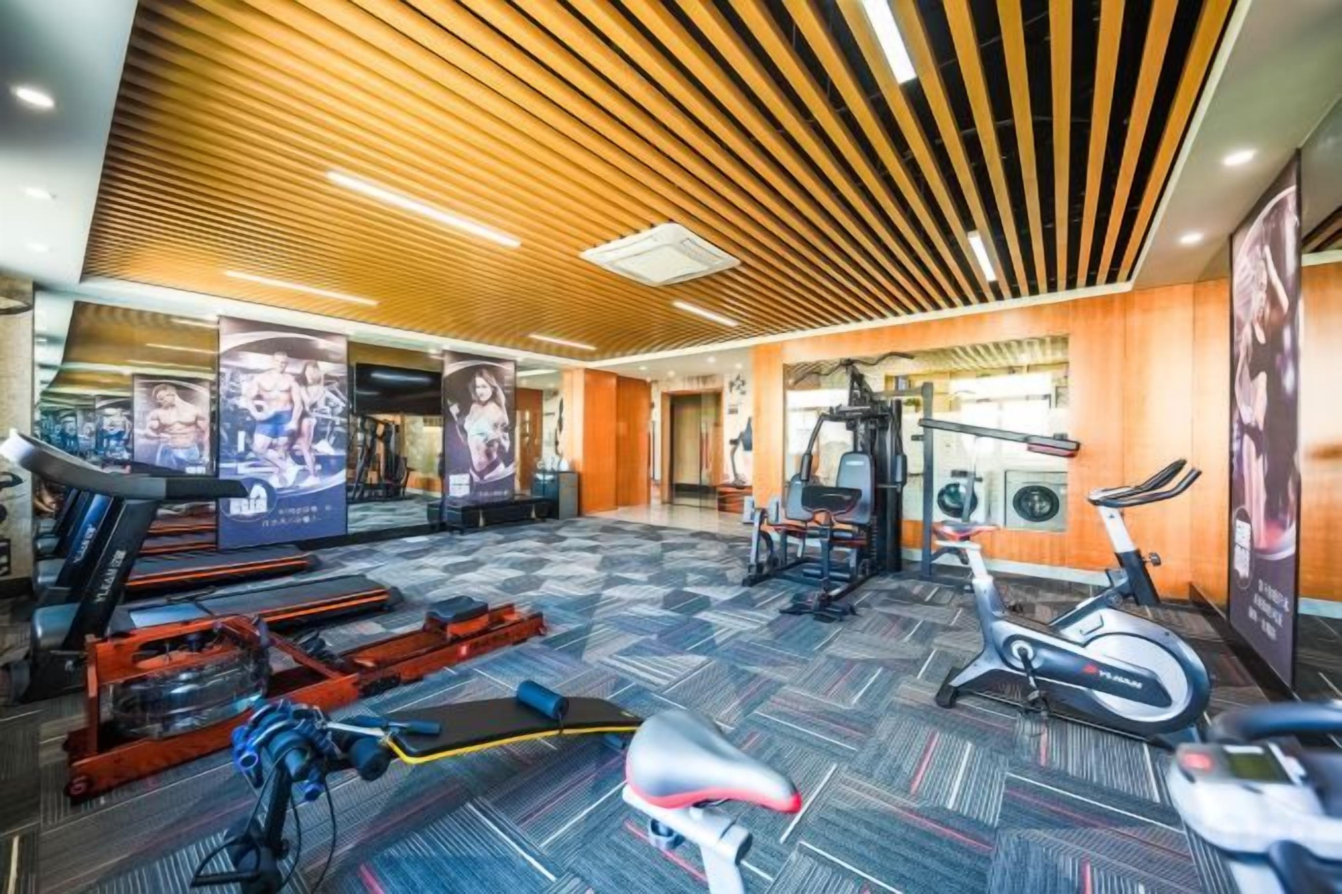 A gym with exercise equipment, a treadmill, and a stationary bike.
