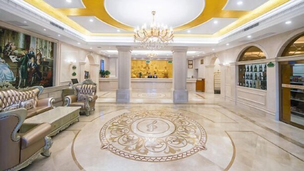 A luxurious lobby with ornate furniture, a grand chandelier, and a central decorative floor design. - Vienna Hotel (Jishou Qianzhou Ancient City Branch) (Jishou)