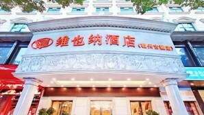 A hotel entrance with a classical architectural design, featuring a prominent sign with Chinese characters. - Vienna Hotel (Jishou Qianzhou Ancient City Branch) (Jishou)
