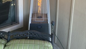 A portable electric heater with a metal frame and a black base, placed against a wooden wall. - Charming new home near Canyon Lake/Guadalupe River (Canyon Lake)