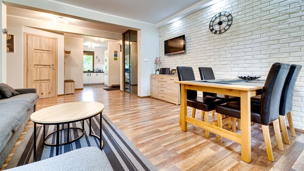 A modern living room with a dining area, wooden flooring, and a brick wall. - Karpacz Boczna by Interhome (Karpacz)