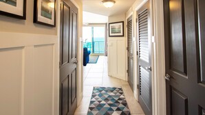 Un couloir avec un tapis à motifs, des portes et une vue sur un balcon.