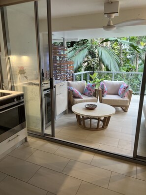 Enjoy meals in the kitchen with a stainless steel stove and oven, then dine in the adjacent dining area with a round table and sofa.