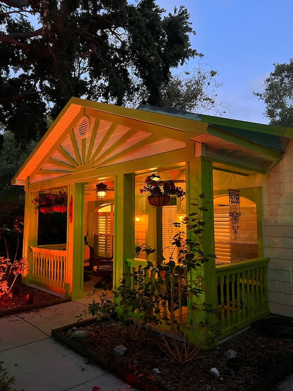 A small, single-story house with a porch, a front door, and a window.