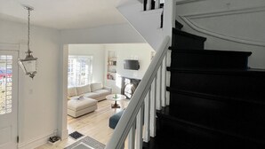 A spacious living area with a staircase leading to an upper floor. - "The Cottage" Downtown Denver (Denver)