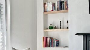 A modern living room with a grey sofa, a round coffee table, and built-in bookshelves against the wall. - "The Cottage" Downtown Denver (Denver)